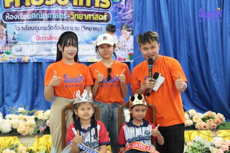 นักเรียนหญิงและชายสวมมงกุฎนั่งด้านหน้า พร้อมทีมงาน Seek Activity สามคนทำท่าชูนิ้วโป้งด้านหลัง