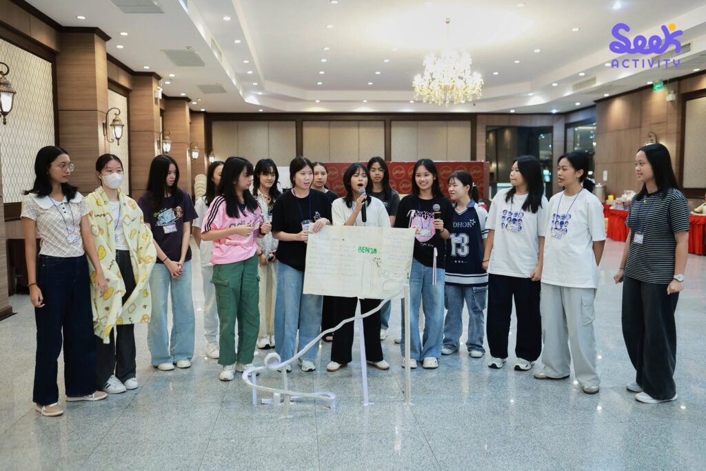 กลุ่มนักเรียนหญิงกำลังนำเสนอผลงานและโครงงานบนกระดาน ในกิจกรรมค่ายวิทยาศาสตร์และภาษาอังกฤษ