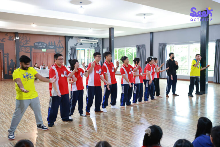 นักเรียนโรงเรียนพระนารายณ์ยืนทำท่าทางร่วมกับวิทยากรระหว่างกิจกรรมค่ายภาษาอังกฤษและภาษาจีน